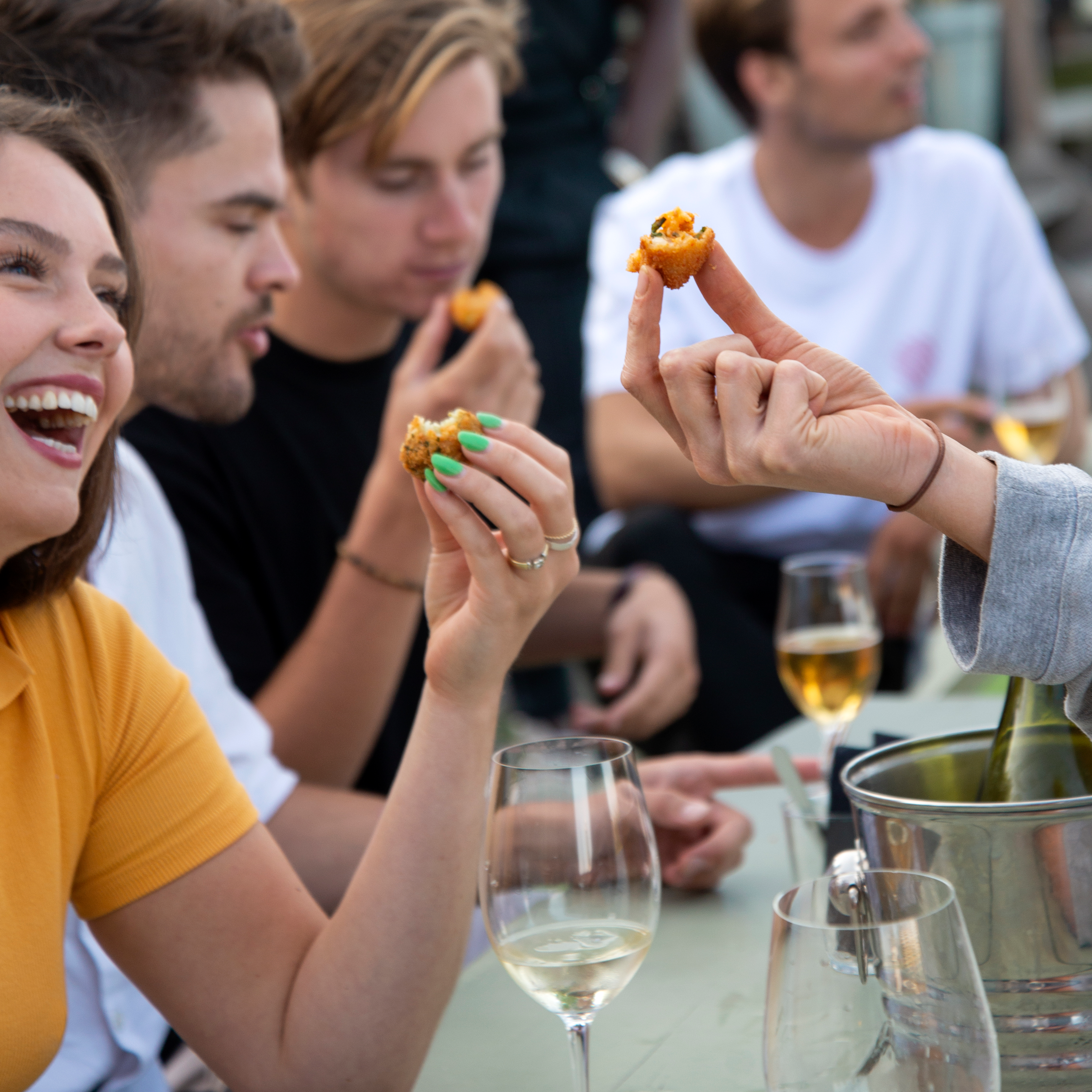 Lachende mensen die arancini en risottini bestellen in de horeca.