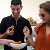Twee mensen die Italiaanse risotto bitterballen eten